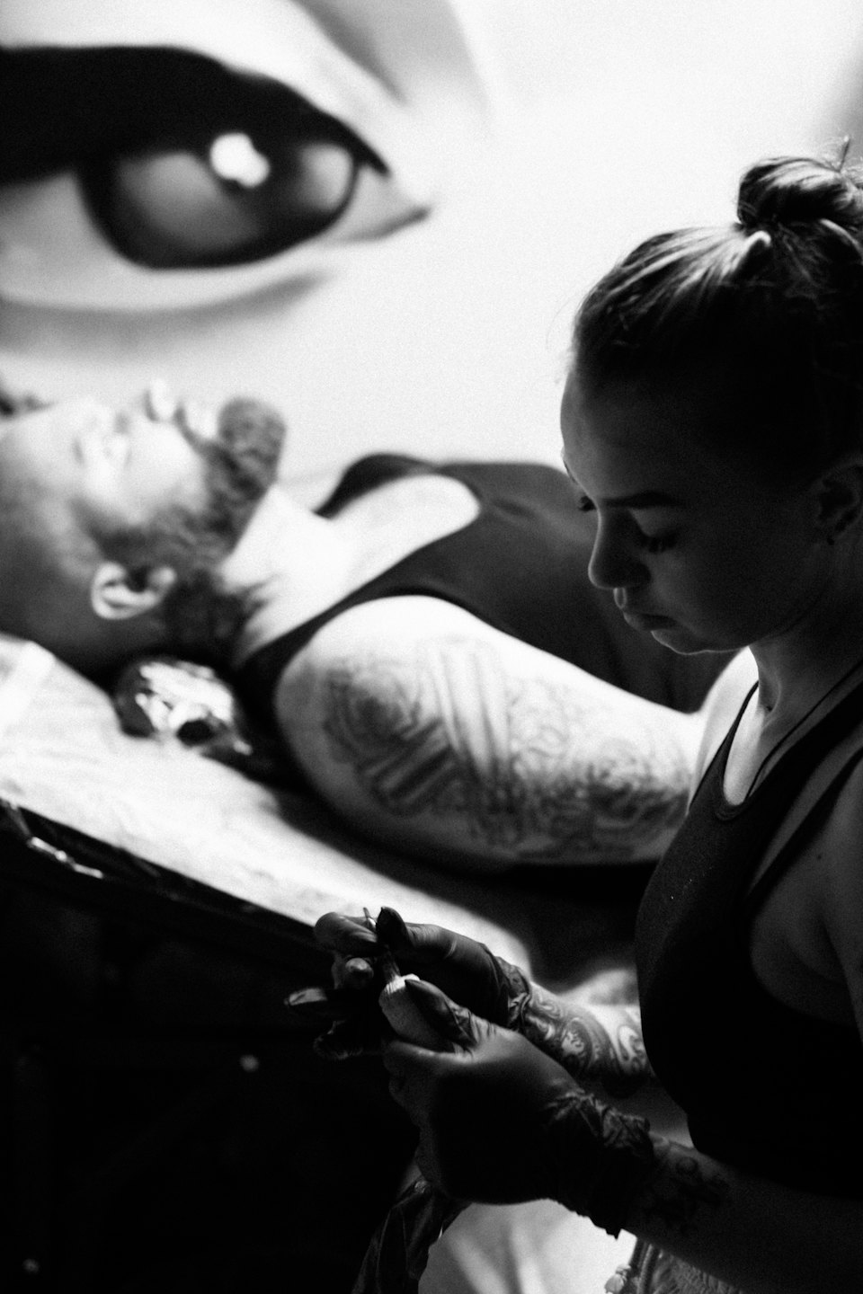 Un tatuatore prepara la sua macchinetta mentre un cliente aspetta.